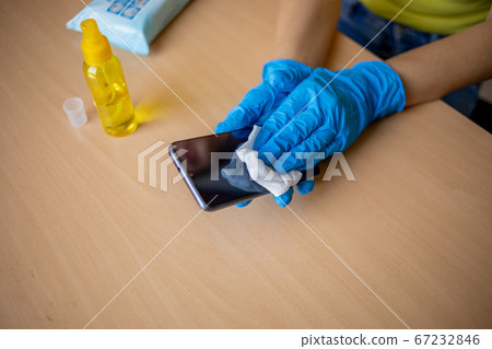 Woman's hand in blue gloves sanitizing cleaning 67232846