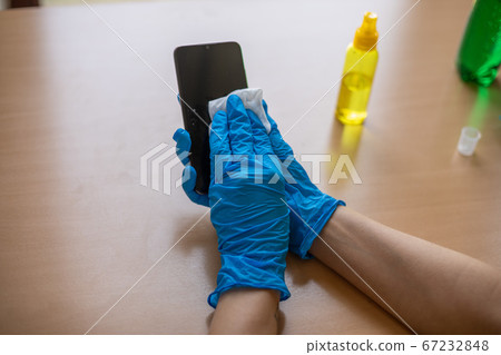 Woman's hand in blue gloves sanitizing cleaning 67232848
