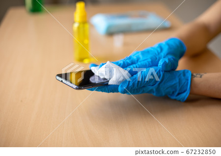 Woman's hand in blue gloves sanitizing cleaning 67232850