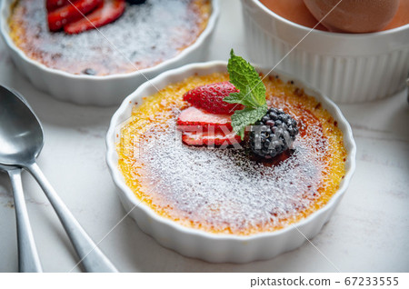 creme brulee with fruits and mint on white creme brulee with fruits and mint on white 67233555