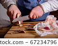 Chef cuts pieces of horse meat on a cutting board with a knife. Master class in the kitchen. The 67234796