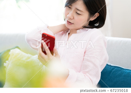 A middle-aged woman with a stiff shoulder [smartphone] 67235018