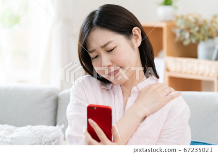 A middle-aged woman with a stiff shoulder [smartphone] 67235021