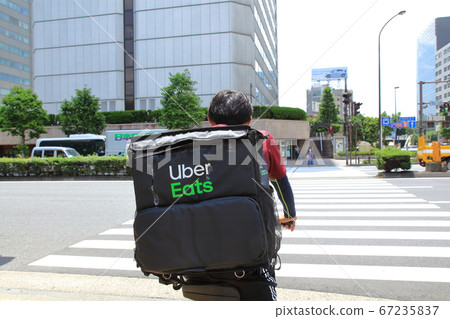 Uber Eats running in the city of Tokyo - Stock Photo [67235837 