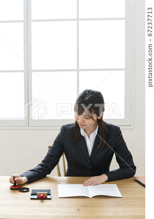 西裝印在桌子上的文件中的女人 67237713