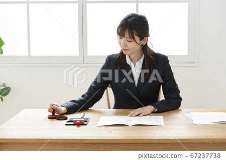 西裝印在桌子上的文件中的女人 67237738