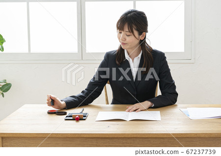 西裝印在桌子上的文件中的女人 67237739