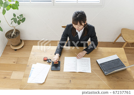 西裝印在桌子上的文件中的女人 67237761