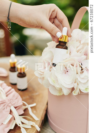 Businesswoman putting serum in flower box 67238072