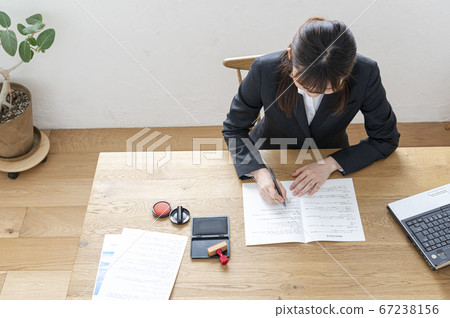 Woman in business suit imprinting documents at desk 67238156