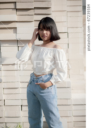 asian teenager sitting on stack of contruction asian teenager sitting on stack of contruction 67239384