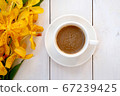 Top view or flat lay of yellow orchid flowers and a cup of coffee on white wooden background. 67239425
