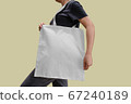 Woman holding white fabric bag isolated with clipping path 67240189