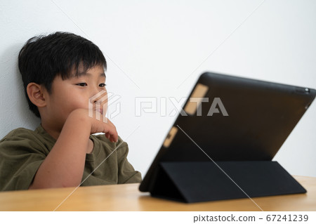 Boy watching tablet Boy watching tablet 67241239