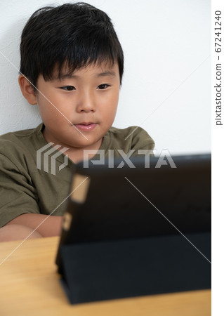 Boy watching tablet 67241240