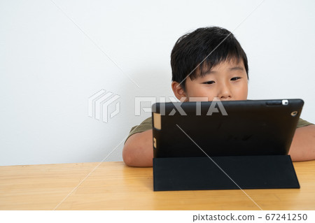 Boy watching tablet Boy watching tablet 67241250