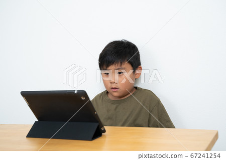 Boy watching tablet Boy watching tablet 67241254