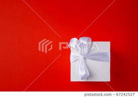 White Gift box on a red background. Space for text. White Gift box on a red background. Space for text. 67242527