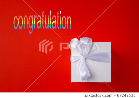 White Gift box on a red background. Space for text. White Gift box on a red background. Space for text. 67242535