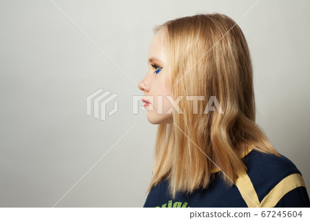 Teen girl with blue eye shadow makeup on white Teen girl with blue eye shadow makeup on white 67245604