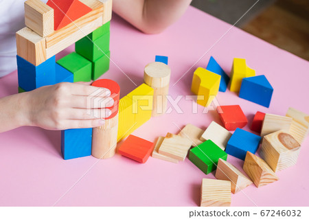 Little kid plays assemble with wooden cubes constructor. Education concept for children learning. Children's toys 67246032