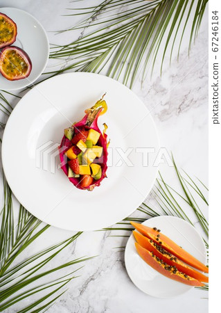 Exotic fruits and tropical leaves on table Exotic fruits and tropical leaves on table 67246184