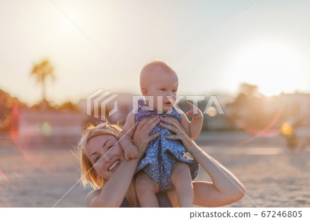 Young mother with her pretty baby girl hanging out on a summer beach Young mother with her pretty baby girl hanging out on a summer beach 67246805