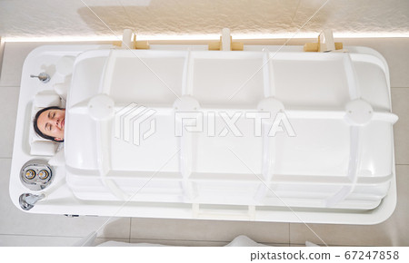 Pleased lady relaxing in comfortable spa capsule Pleased lady relaxing in comfortable spa capsule 67247858