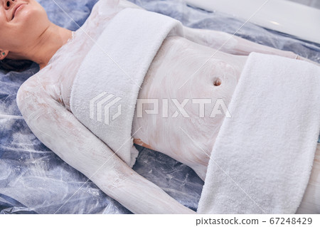 Body of young female with two towels on it in spa treatment Body of young female with two towels on it in spa treatment 67248429