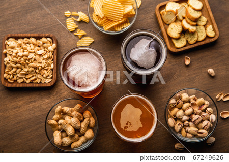 Pint of beer for friends. Craft drinks in glasses and snacks on table Pint of beer for friends. Craft drinks in glasses and snacks on table 67249626