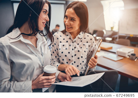 Young businesspeople watching at clipboard working at office workplace Young businesspeople watching at clipboard working at office workplace 67249695