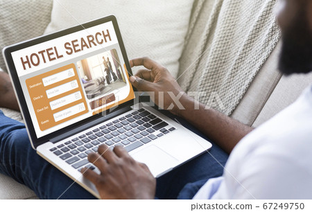 Black man chilling at home, planning vacation, using laptop Black man chilling at home, planning vacation, using laptop 67249750