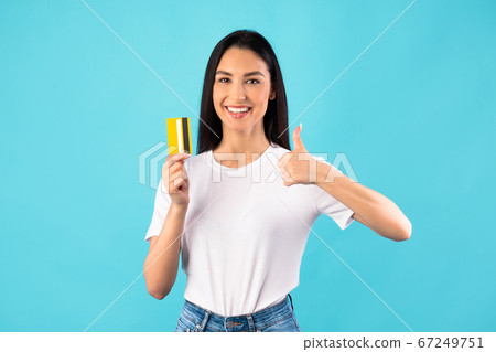 Girl holding credit card and showing thumb up 67249751