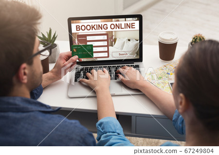 Couple making hotel reservation online, using laptop Couple making hotel reservation online, using laptop 67249804