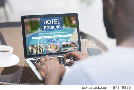 Black man resting at cafe and booking hotel online Black man resting at cafe and booking hotel online 67249856
