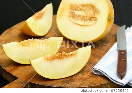 Yellow Melon with slices on a table Yellow Melon with slices on a table 67250441