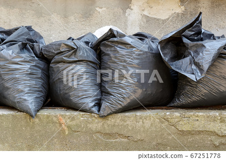 Four filled black bags with construction debris after apartment repair. 67251778