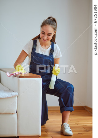 Attractive woman in blue special equipment wiping dust off Attractive woman in blue special equipment wiping dust off 67251984