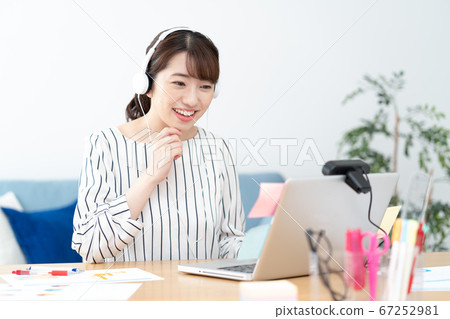遠程辦公少婦佩帶的白色耳機在家網絡會議的 67252981