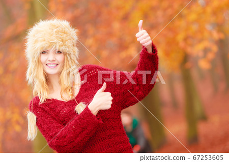 Pretty smiling woman in fur hat with thumb up. Pretty smiling woman in fur hat with thumb up. 67253605