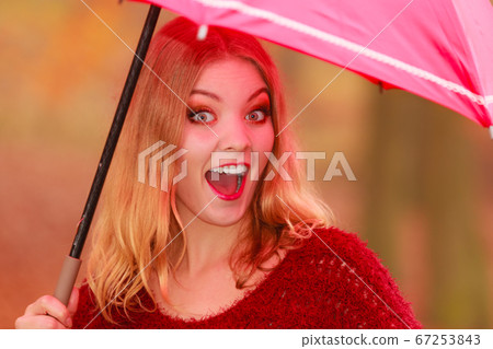 Fashion woman with umbrella relaxing in fall park. 67253843