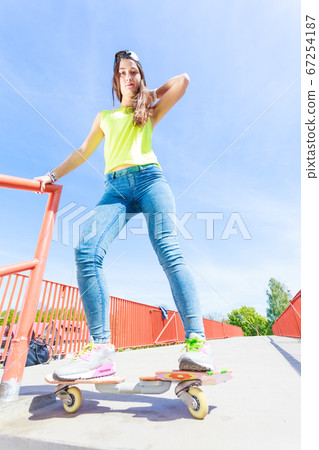 Teen girl skater riding skateboard on street. Teen girl skater riding skateboard on street. 67254187