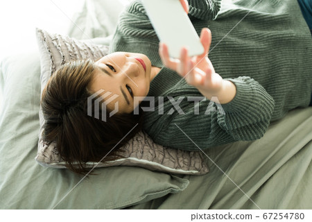 Woman in her twenties looking at a smartphone Woman in her twenties looking at a smartphone 67254780
