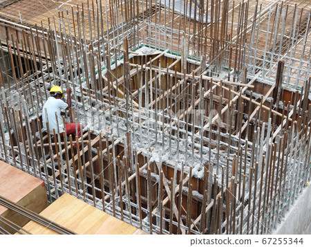 SEREMBAN, MALAYSIA -MARCH 29, 2020: Construction workers fabricating steel reinforcement bar at the construction site. They tied it together using the tiny wires. It is one of the steps in making of r SEREMBAN, MALAYSIA -MARCH 29, 2020: Construction workers fabricating steel reinforcement bar at the construction site. They tied it together using the tiny wires. It is one of the steps in making of r 67255344