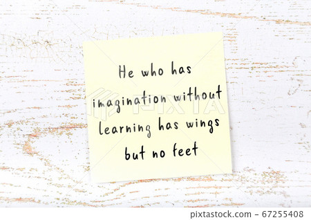 Wise quote on sticky note on wooden wall  67255408