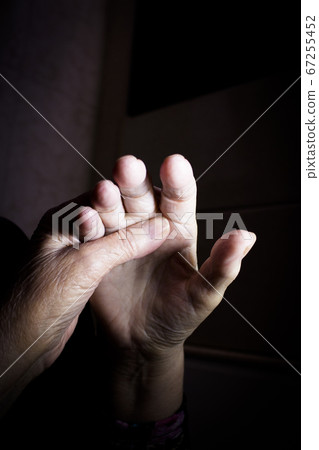 Hands of elderly woman doing a selfmassage 67255452