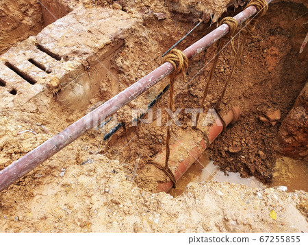 KUALA LUMPUR, MALAYSIA -JUNE 02, 2017: Underground utility and services pipe laid by workers in the trenches at the construction site. Installation of stop cork valve and joint in progress.    67255855