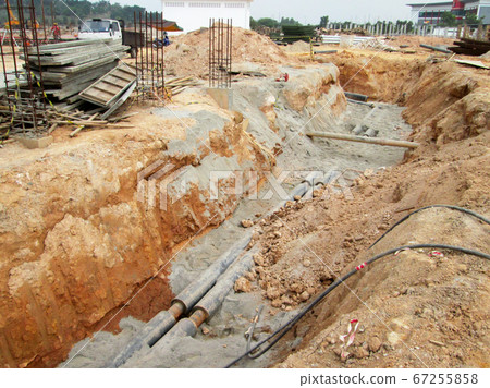 KUALA LUMPUR, MALAYSIA -JUNE 02, 2017: Underground utility and services pipe laid by workers in the trenches at the construction site. Installation of stop cork valve and joint in progress.    67255858