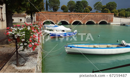 Amazing panoramic view of Peschiera del Garda, Italy. Sky before the rain, boats in the water near the bridge 67259487