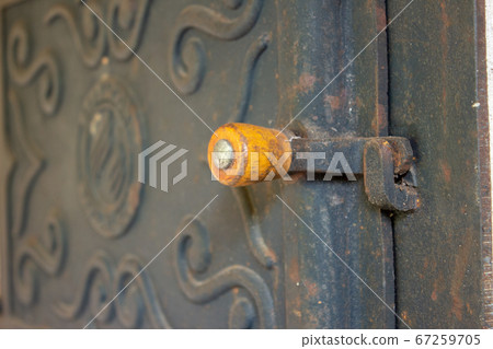 The wooden handle of a wood burning stove door, with details engraved on the stove door The wooden handle of a wood burning stove door, with details engraved on the stove door 67259705